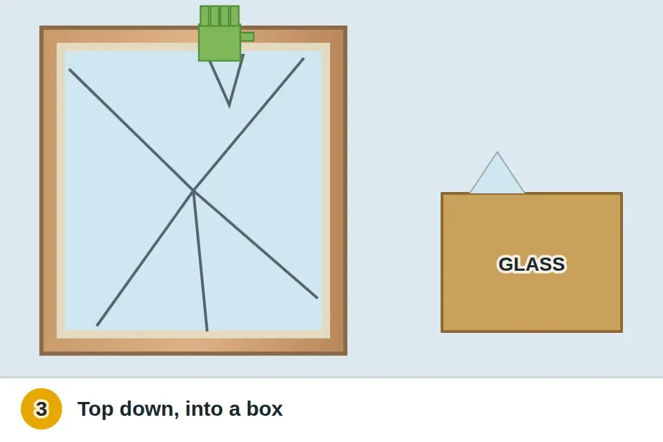 Gloved hand wiggling loose glass shards out of the frame from the top down and placing them in a sturdy cardboard box