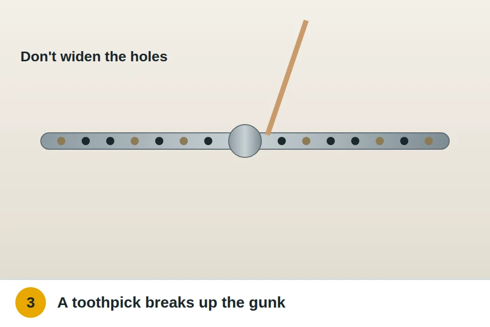 Toothpick poking debris out of the small spray holes on a dishwasher arm