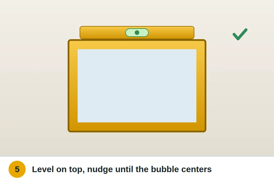Level resting on top of a hung mirror with the bubble centered