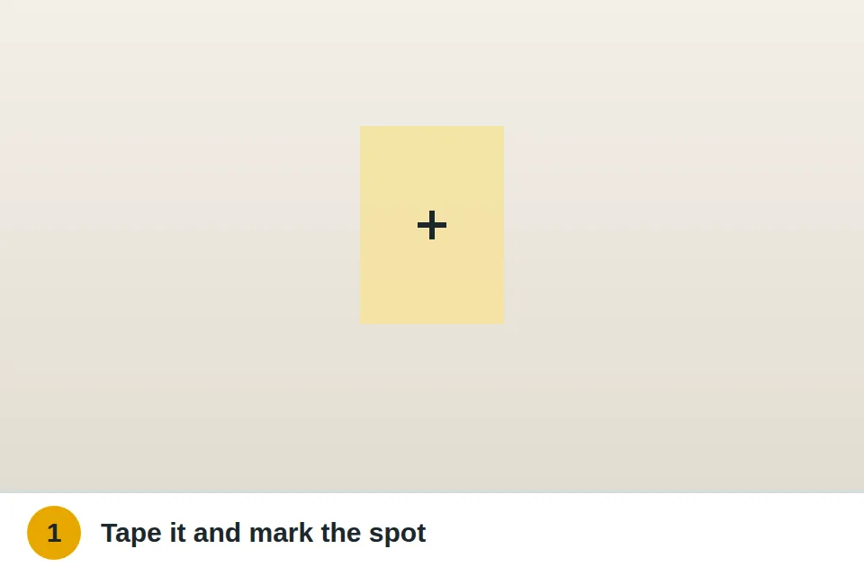 Painter's tape stuck to a plaster wall with the hole position marked on it