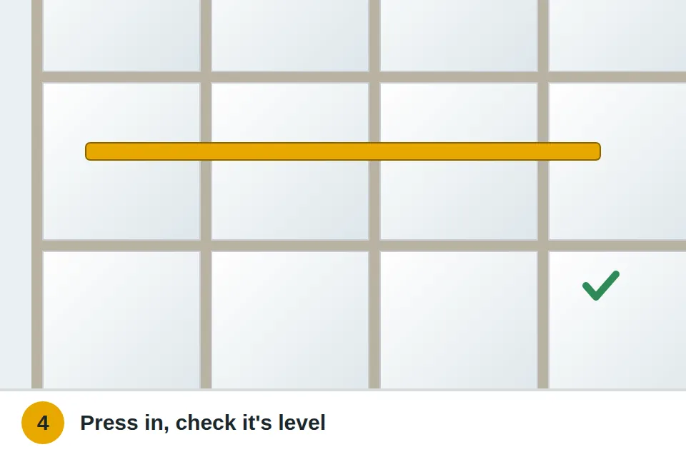 New tile pressed into fresh thinset and checked level with a straightedge across its neighbors