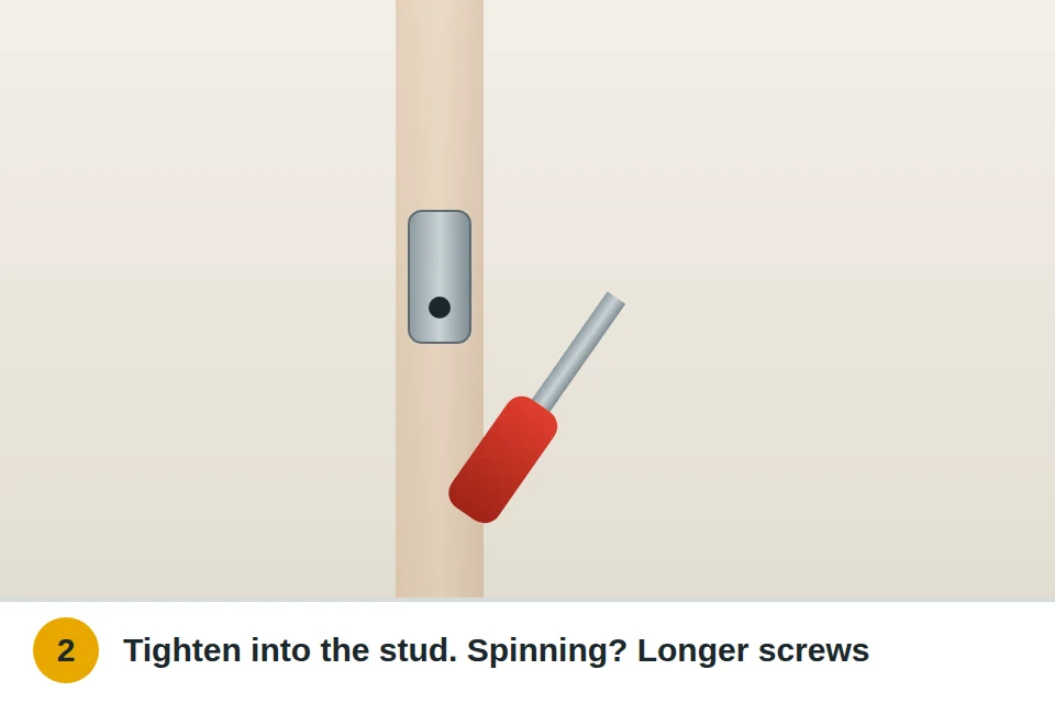 Screwdriver tightening the screws on a handrail wall bracket into a stud