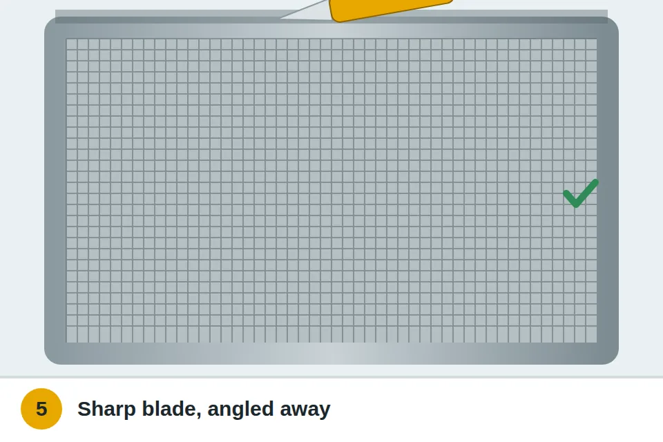 Utility knife trimming extra mesh along the outside edge of the spline, angled away from the screen